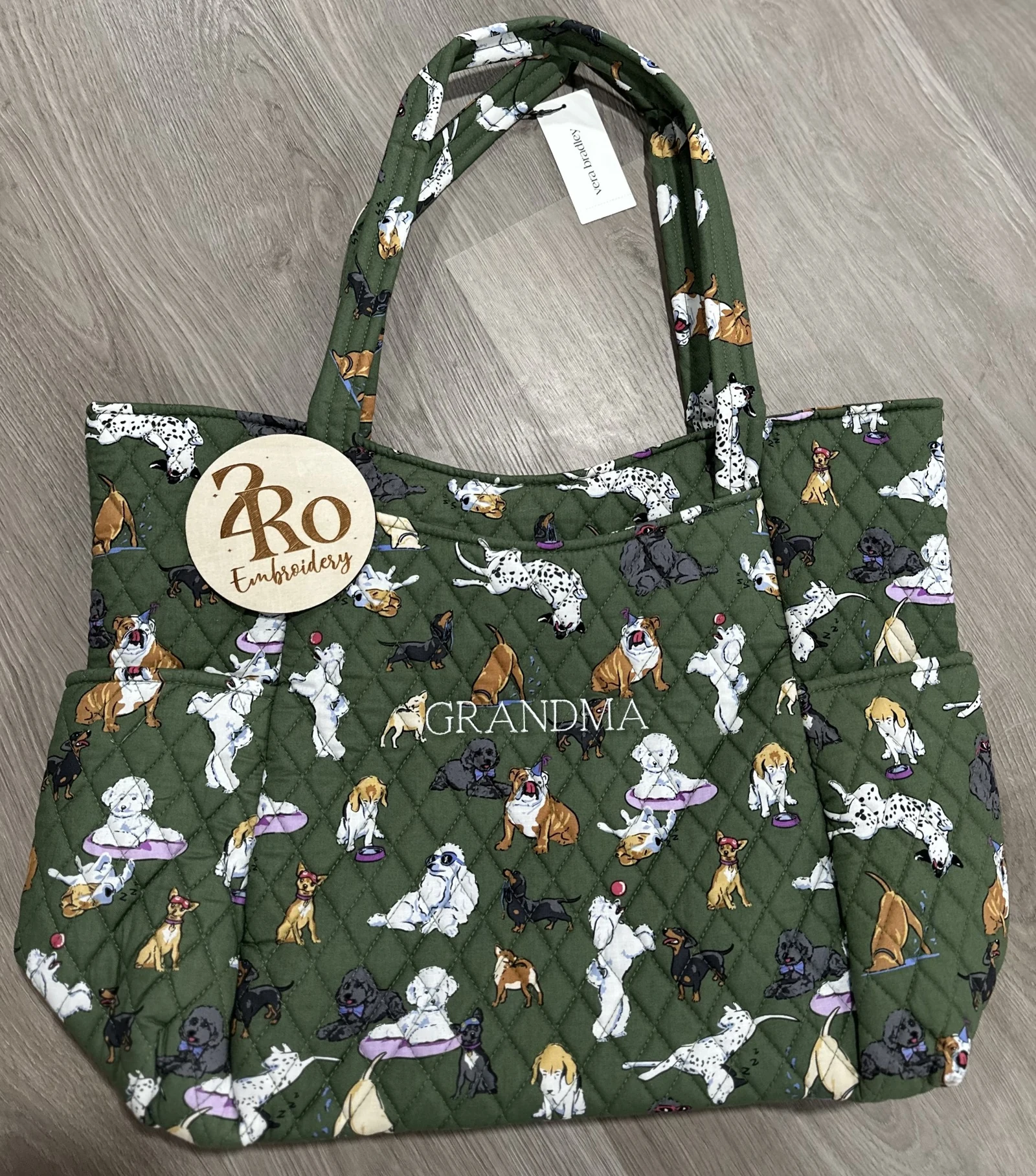 Green quilted tote covered in illustrated dogs, embroidered with GRANDMA in white