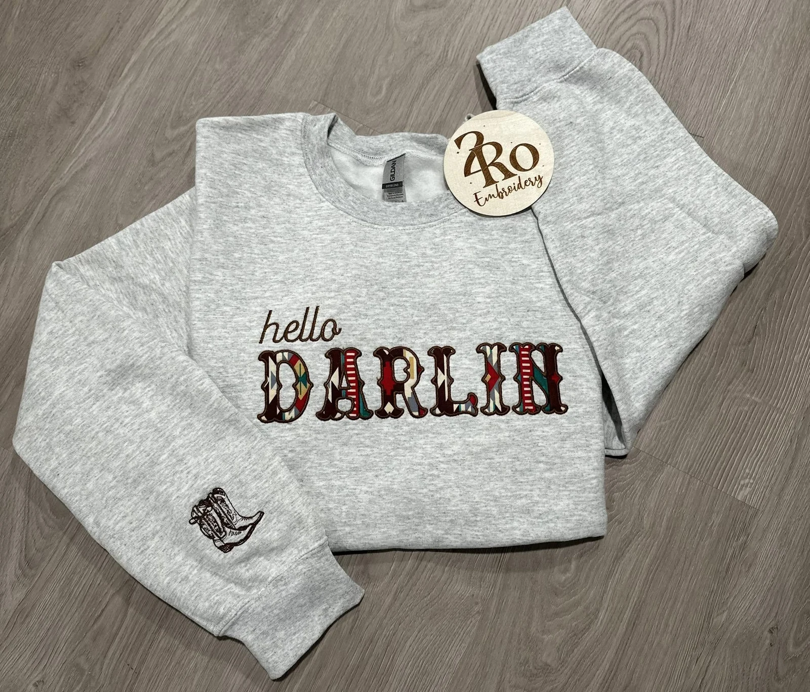 Gray Hello Darlin sweatshirt with colorful patterned lettering and embroidered cowboy boots on the sleeve