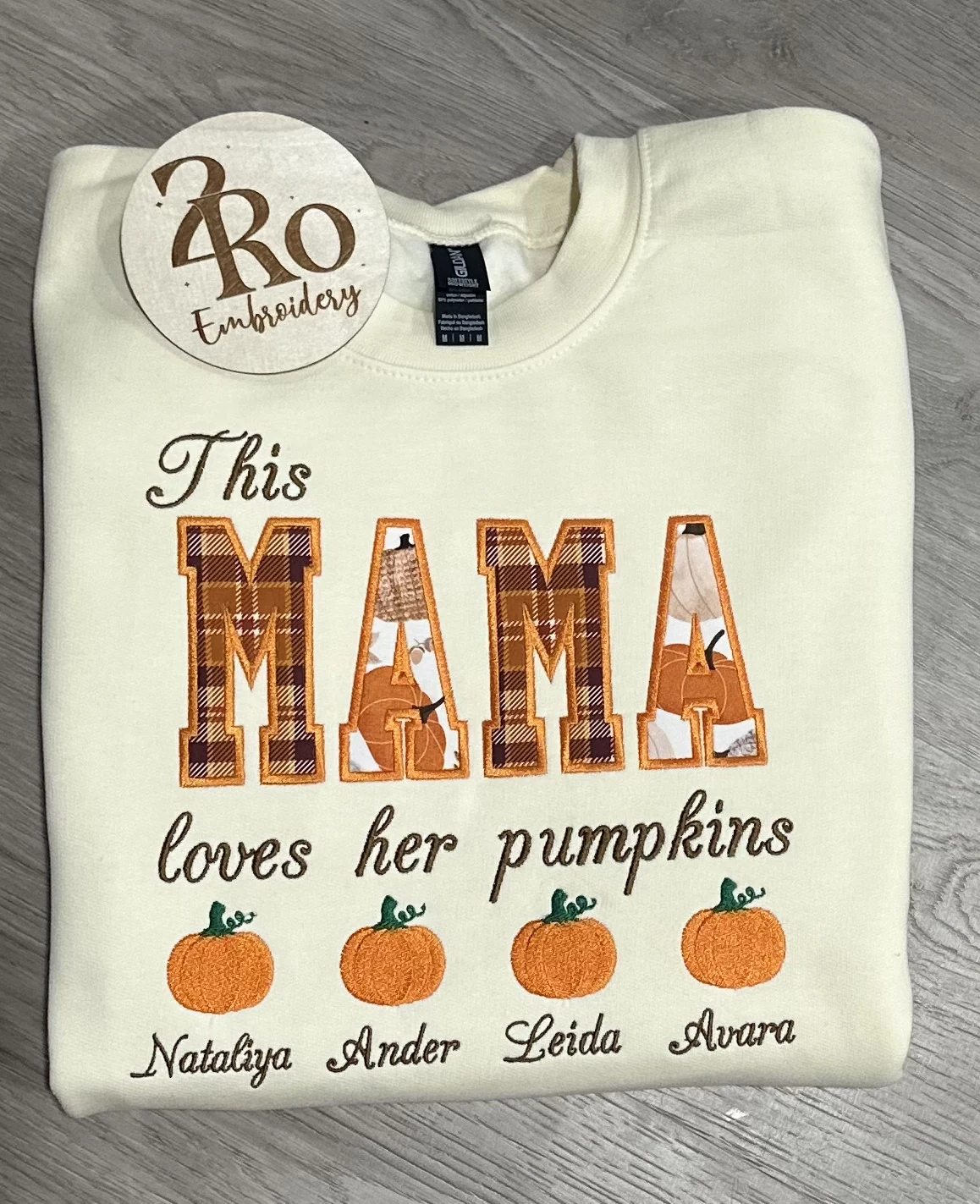 Cream sweatshirt with plaid and pumpkin-print appliqué MAMA letters, loves her pumpkins in script, and four named pumpkins
