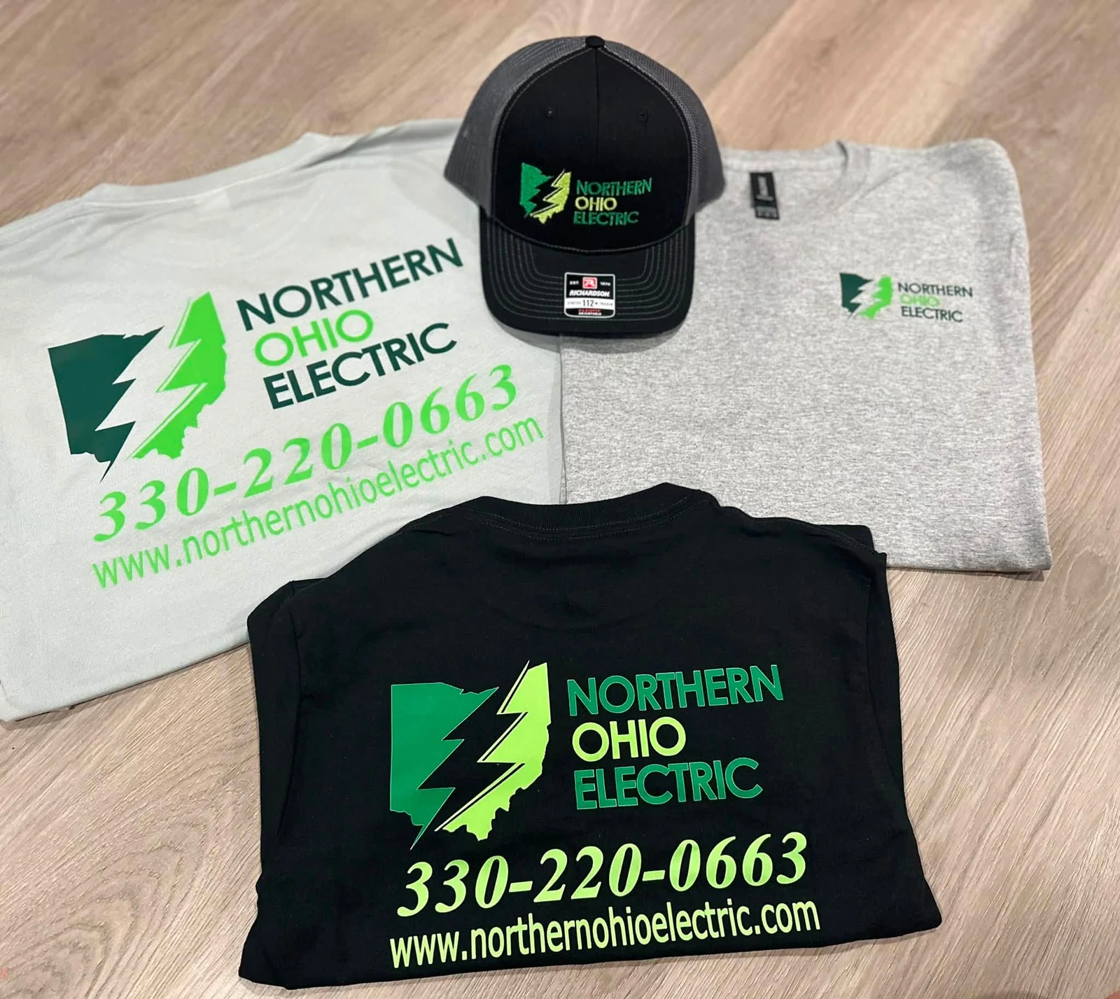 Black embroidered Northern Ohio Electric cap alongside gray and black branded shirts